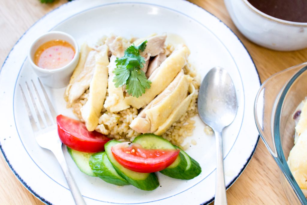 hainanese chicken rice on a white plate.